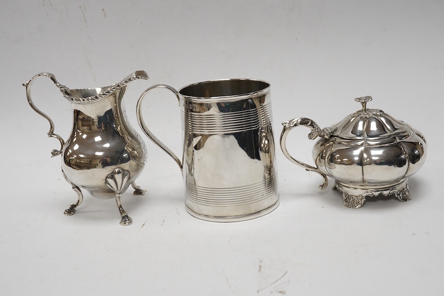 A George III silver cream jug, marks rubbed, a George III silver christening mug, London, 1801 and a William IV silver melon shaped mustard pot, John, Henry & Charles Lias, London, 1835. Condition - poor to fair